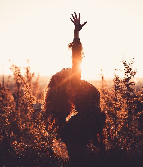 Silhouette of a woman stretching during sunrise, full of vitality.