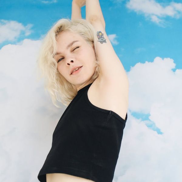 Woman with arms outstretched towards the sky, looking energetic and happy.